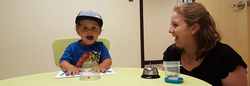 A family dev lab staffer playing the snack game with an excited toddler